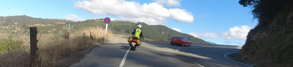A motorcycle rider taking a tight curve to the right on the open road